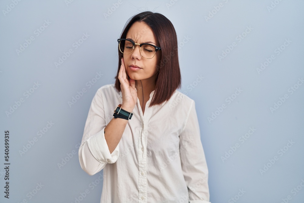 Young hispanic woman standing over white background touching mouth with hand with painful expression because of toothache or dental illness on teeth. dentist Young hispanic woman standing over white background touching mouth with hand with painful expression because of toothache or dental illness on teeth. dentist