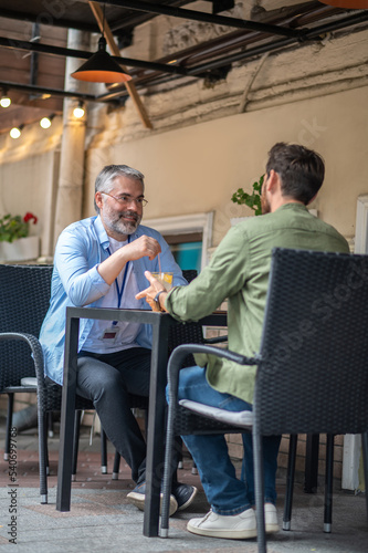 Two men sitting in the cafe and having an interesting conversation