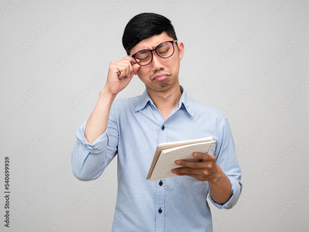 Asian businessman holding the diary feels tried and bored isolated Asian businessman holding the diary feels tried and bored isolated