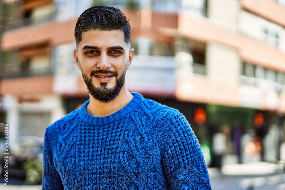 Young arab man smiling confident at street