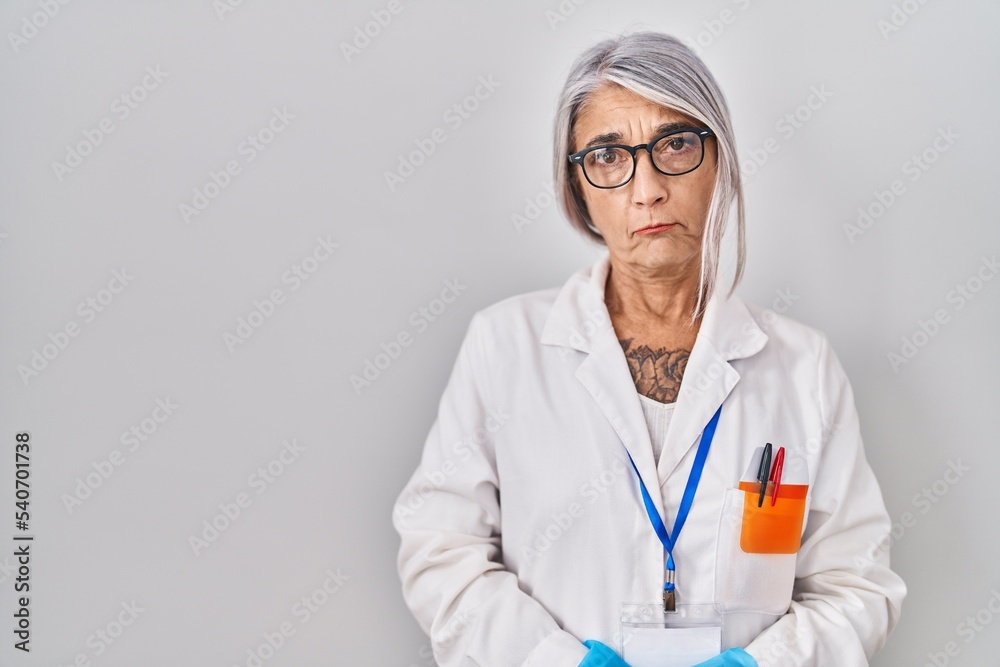 Middle age woman with grey hair wearing scientist robe depressed and worry for distress, crying angry and afraid. sad expression. Middle age woman with grey hair wearing scientist robe depressed and worry for distress, crying angry and afraid. sad expression.