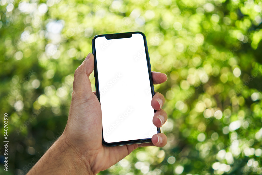 Man holding smartphone showing white blank screen at park