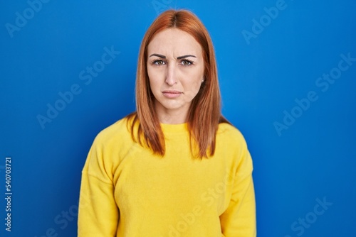 Young woman standing over blue background skeptic and nervous, frowning upset because of problem. negative person.