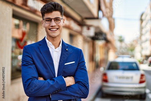 Young man smiling confident wearing suit and glasses at street © Krakenimages.com