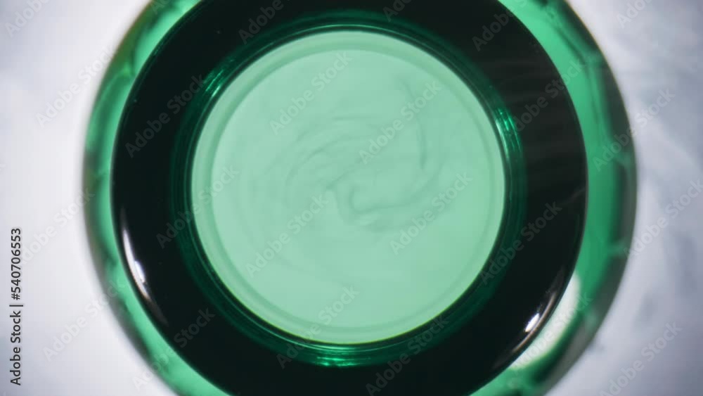 Craft drink opened flask top view. Hoppy fresh beer in green vessel closeup Craft drink opened flask top view. Hoppy fresh beer in green vessel closeup