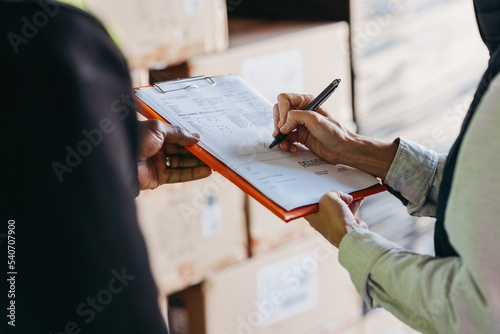 Warehouse manager signing a bill of lading on a clipboard photo