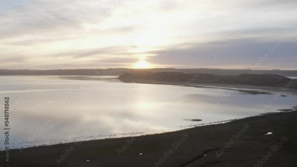 Silver sunrise dawn aerial over low sand dune calm water lagoon Silver sunrise dawn aerial over low sand dune calm water lagoon