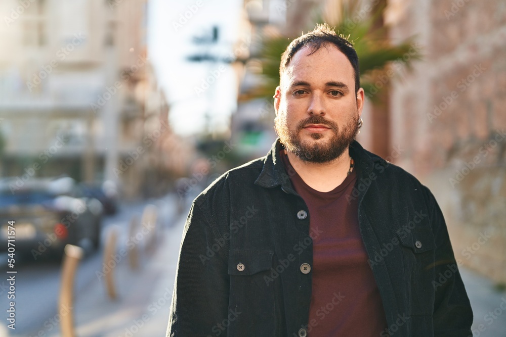 Young hispanic man with relaxed expression standing at street Young hispanic man with relaxed expression standing at street
