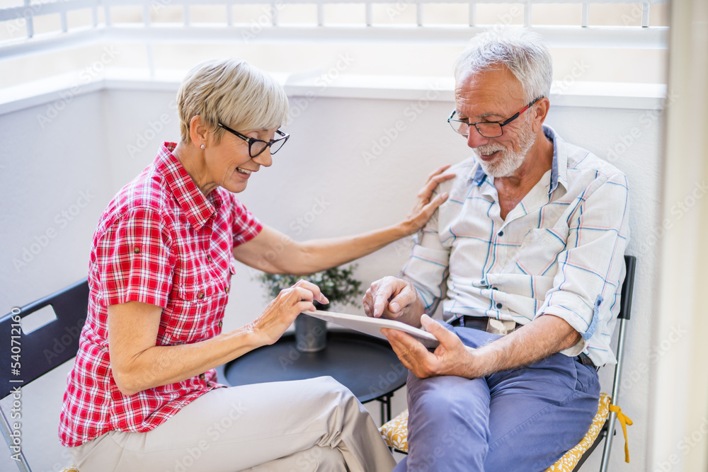 Obraz premium Senior couple sitting and talking on terrace at their home. Leisure time.