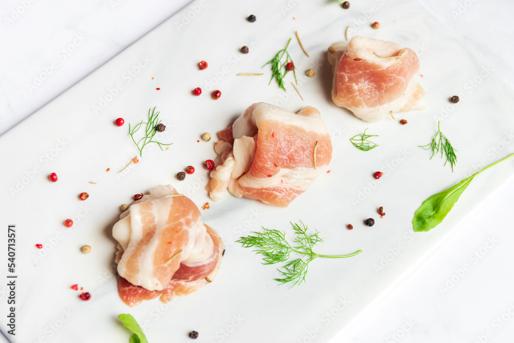 Bacon slide with herb on white marble plate background. Bacon slide with herb on white marble plate background.