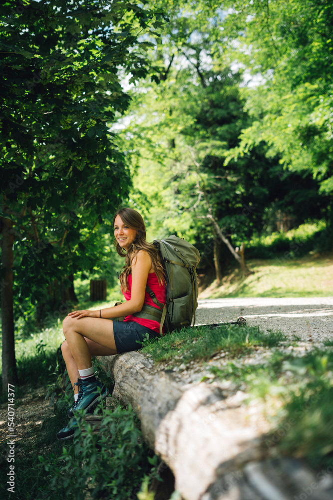 Smiling backpacker sitting at roadside Smiling backpacker sitting at roadside
