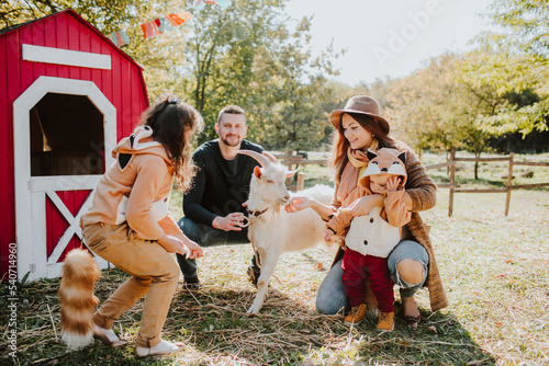 Smiling parents with children wearing fox costume at farm photo