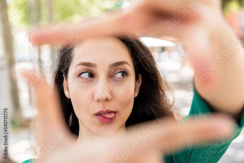 Woman sticking out tongue and making finger frame with hands photo