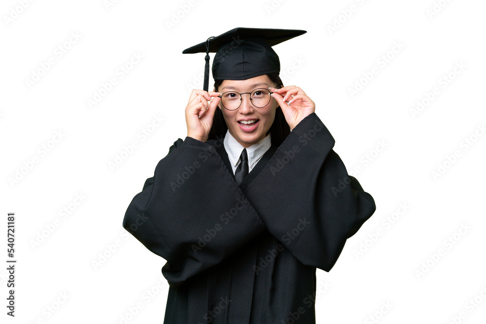Young university graduate Asian woman over isolated background with glasses and surprised Young university graduate Asian woman over isolated background with glasses and surprised