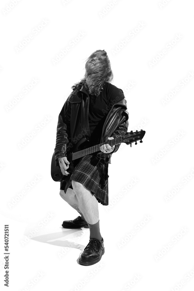 Portrait of expressive young man with long hair, rock musician playing guitar over white background. Black and white photography Portrait of expressive young man with long hair, rock musician playing guitar over white background. Black and white photography