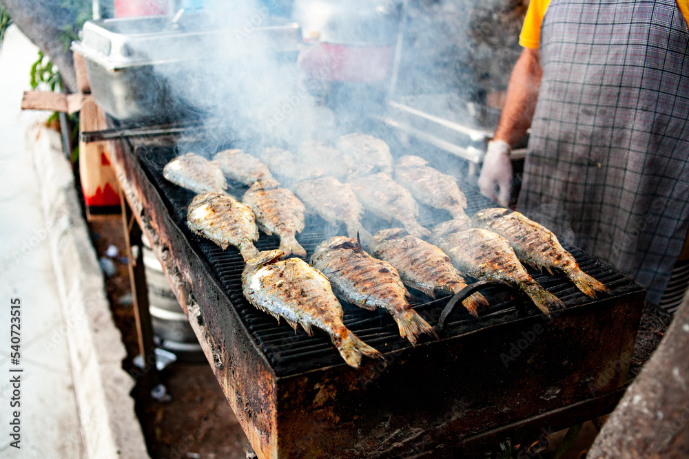 Grilled fish. Grilling dorada fish on grill. Frying fish on grill in open air restaurant. Selective focus. Grilled fish. Grilling dorada fish on grill. Frying fish on grill in open air restaurant. Selective focus.