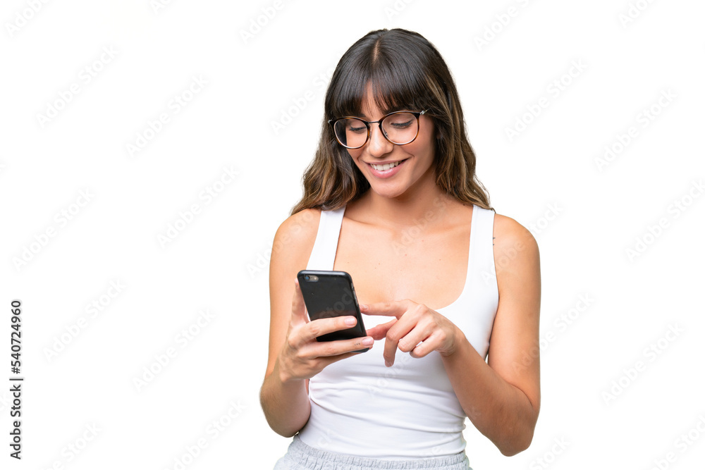 Young caucasian woman over isolated background sending a message or email with the mobile Young caucasian woman over isolated background sending a message or email with the mobile