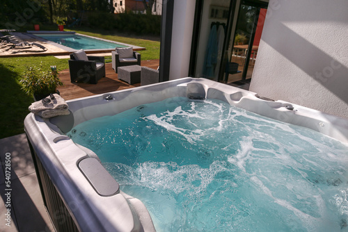 Fototapeta spa sur terrasse en extérieur avec piscine  à coté de la maison
