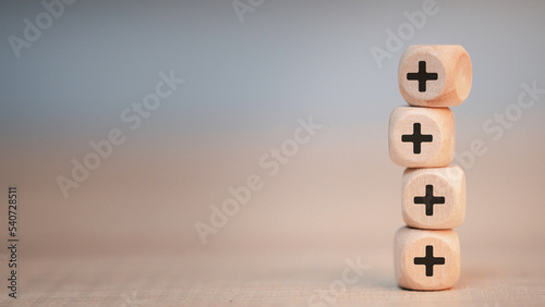 Plus sign in wooden cube block stacking. Addition and positive mindset thinking  such as profit, benefits, development, CSR represented, motivation, increase concept and copy space.
