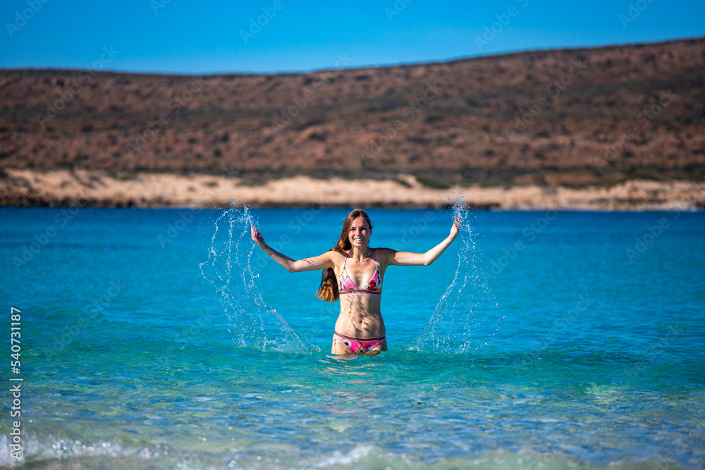 A beautiful girl plays in the turquoise water at ningaloo reef in cape range national park in western australia, swimming on a coral reef near exmouth