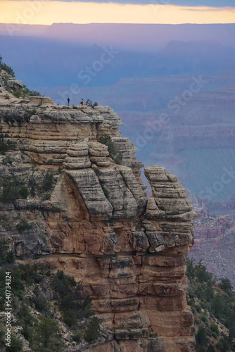 Grand Canyon National Park, Arizona: Tourists on Grand View Point enjoy the muted colors of sunset under a cloudy sky. Viewed from Mather Point, on the South Rim.