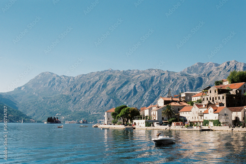 Embankment of Perast with old stone houses against the backdrop of mountains