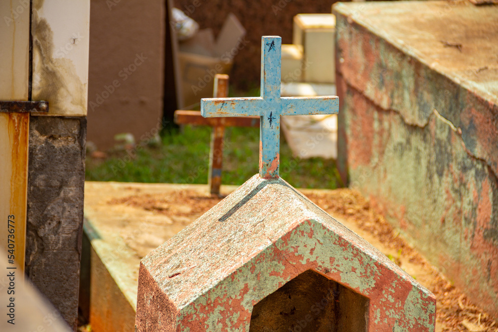 Detalhes de um cemitério com vários túmulos e cruzes.