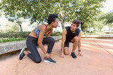 Couple getting ready for jogging. Man and woman tying shoes, in position for starting jogging. Sport concept