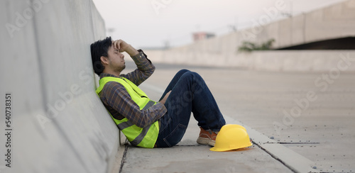 Asian construction workers sit stressed and anxious from working at construction sites.