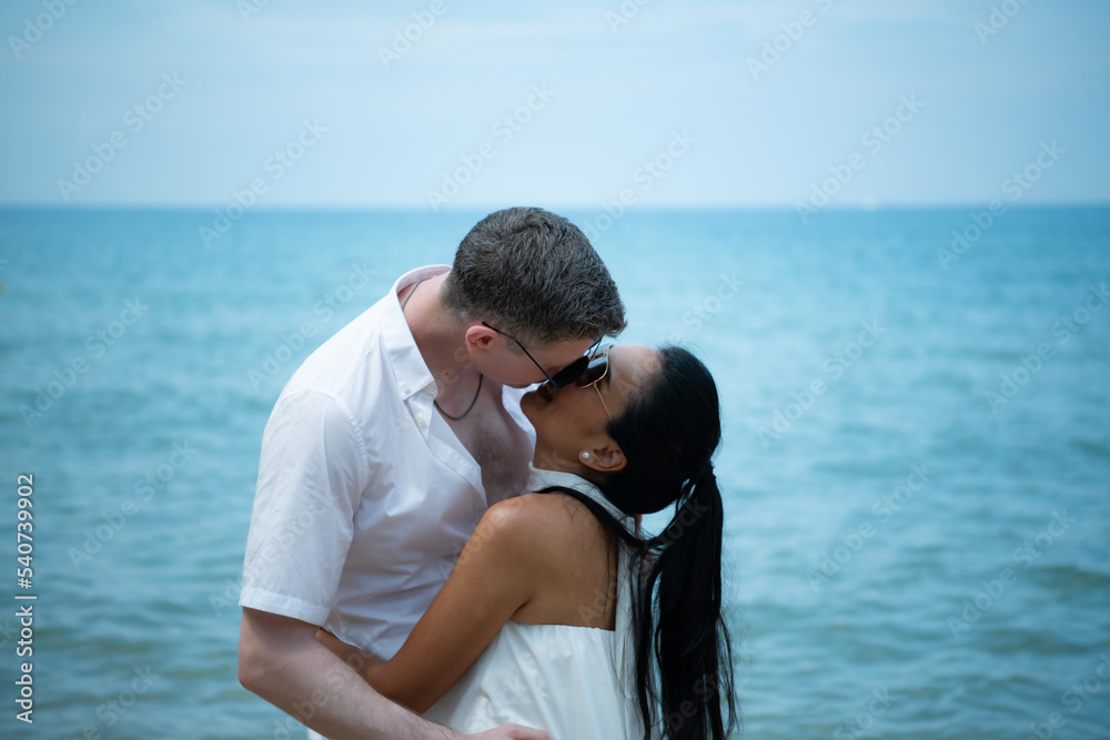 Interracial couple with the joy of traveling to the beautiful blue sea like the paradise
