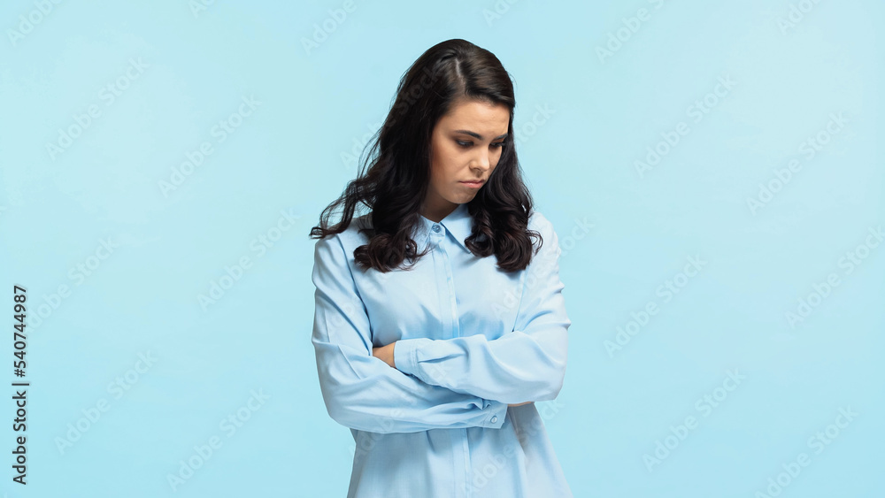 sad young woman in shirt standing with crossed arms isolated on blue sad young woman in shirt standing with crossed arms isolated on blue
