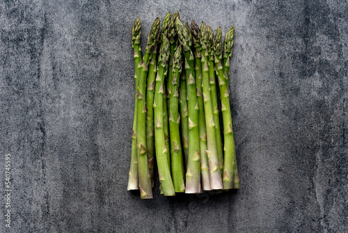 Green fresh raw asparagus on concrete background.Bunch of fresh asparagus top view on gray concrete background