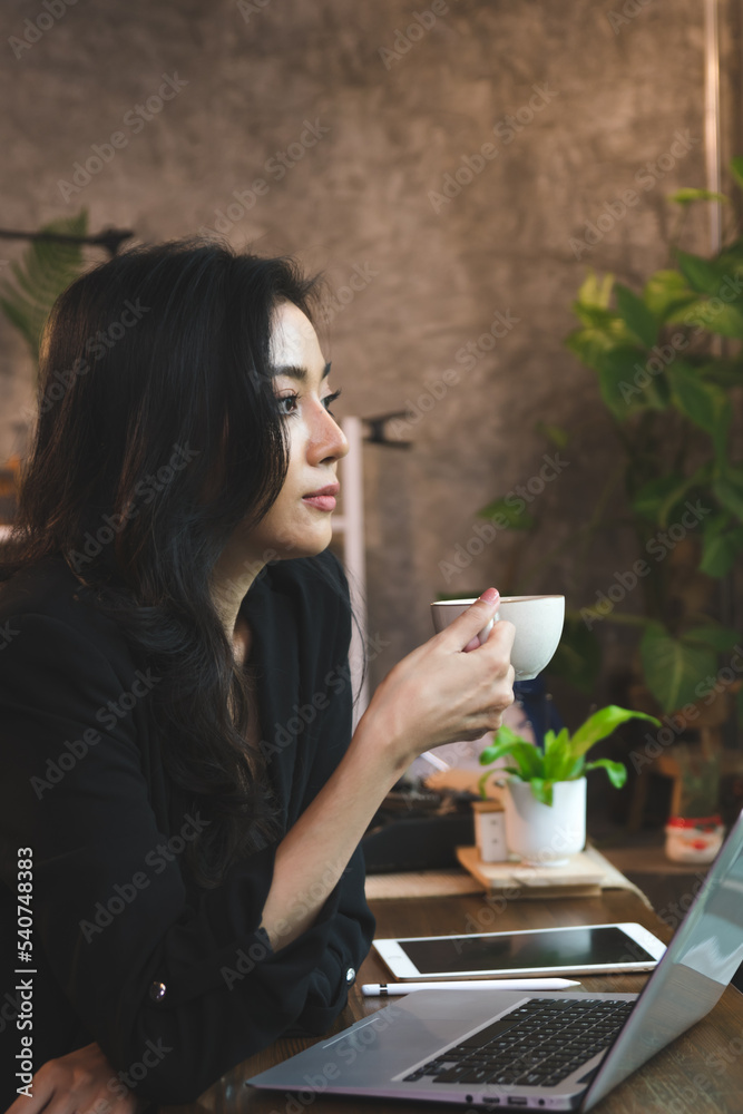 Lifestyle of female entrepreneur sitting at a modern coffee shop, businesswoman using laptop to communicate with partner to discuss her business via internet technology. Lifestyle of female entrepreneur sitting at a modern coffee shop, businesswoman using laptop to communicate with partner to discuss her business via internet technology.