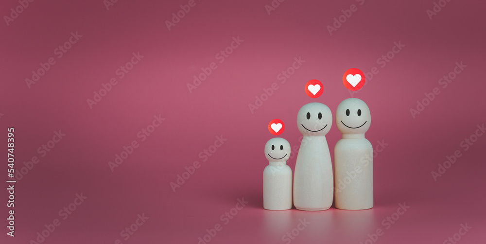 Happy house concept. Wooden dolls stand lined up with heart icons. Indicates happiness and love in the home.