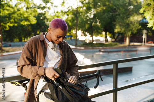 Fotografía Young handsome stylish short-haired smiling boy rummaging in his backpack