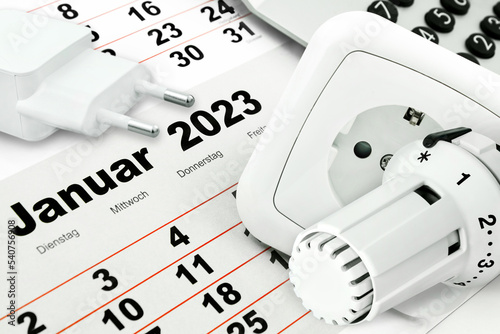 Deutscher Kalender Januar 2023 mit Steckdose, Rechner und Heizungsthermostat  im Winter photo