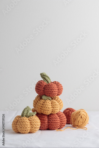 Cute crochet knitted yellow and orange pumpkins on white background
