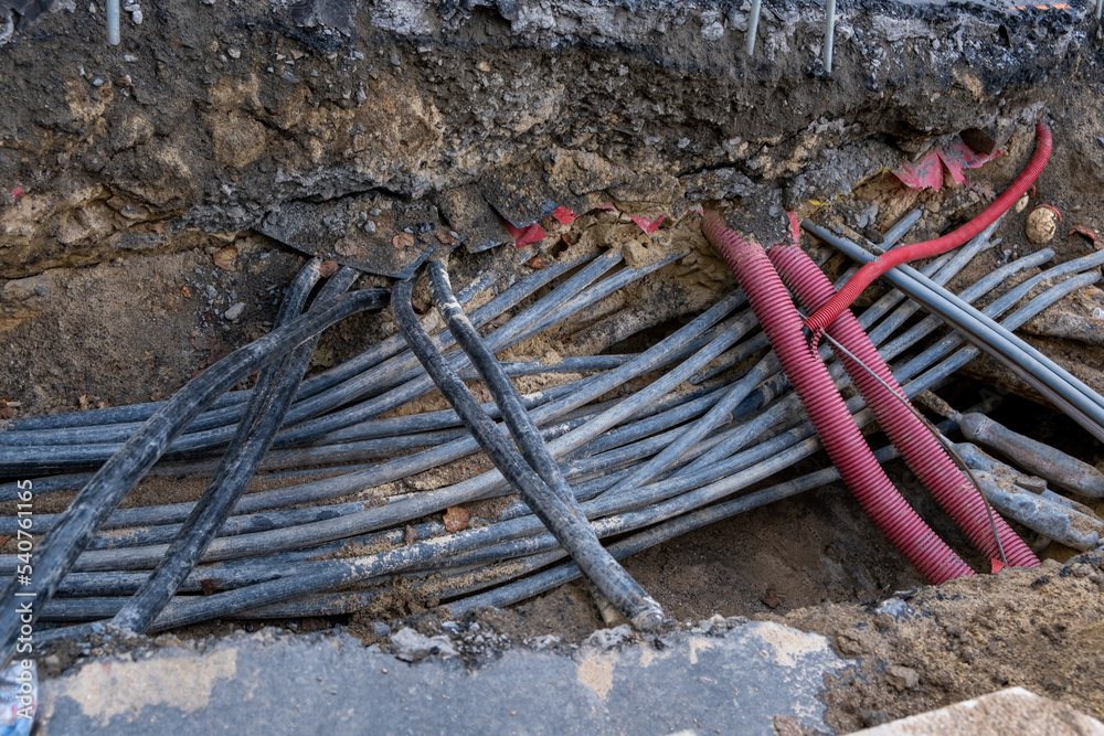 Connecting fiber optic internet connection network cables. Upgrade infrastructure in the city. Construction site with a lot of high speed communication cables buried underground in the street. Connecting fiber optic internet connection network cables. Upgrade infrastructure in the city. Construction site with a lot of high speed communication cables buried underground in the street.