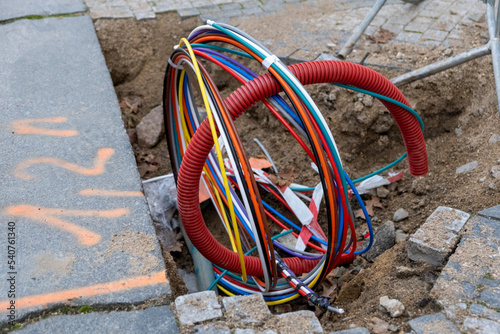 Connecting fiber optic internet connection network cables. Upgrade infrastructure in the city. Construction site with a lot of high speed communication cables buried underground in the street.
