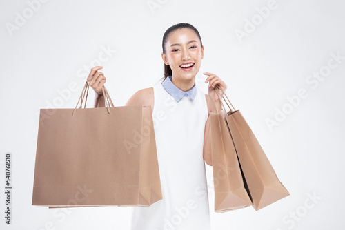 Beautiful Attractive Asian Woman smile and holding luxury shopping bags feeling so happiness and enjoy with black Friday sale in Shopping mall,isolated on white background. Shopping Lifestyle Concept