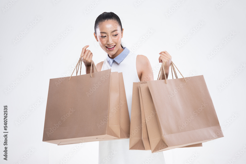 Beautiful Attractive Asian Woman smile and holding luxury shopping bags feeling so happiness and enjoy with black Friday sale in Shopping mall,isolated on white background. Shopping Lifestyle Concept Beautiful Attractive Asian Woman smile and holding luxury shopping bags feeling so happiness and enjoy with black Friday sale in Shopping mall,isolated on white background. Shopping Lifestyle Concept