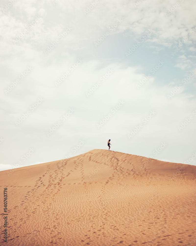 Anonymous woman walking on dune Anonymous woman walking on dune