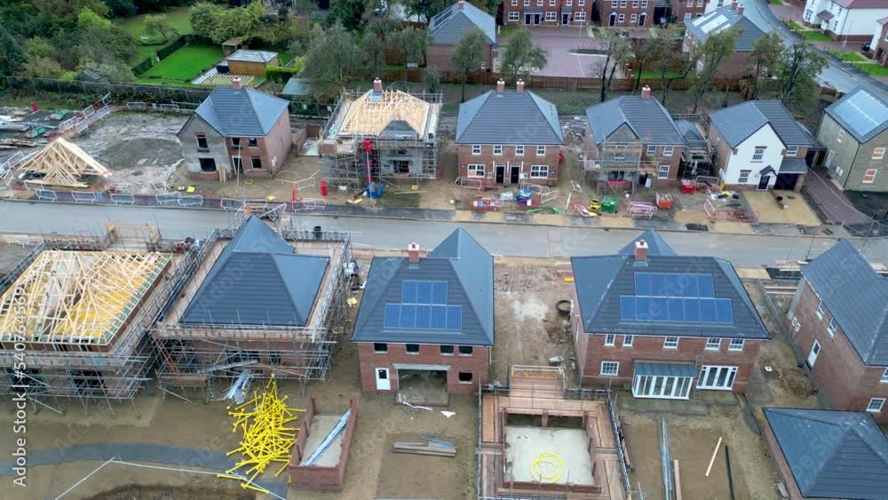 Aerial panning shot of new houses being built with solar panels in UK
