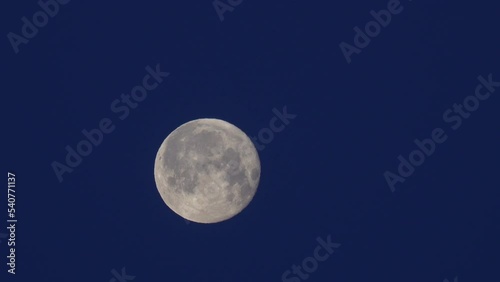 At dusk, the moon moves across the sky. photo