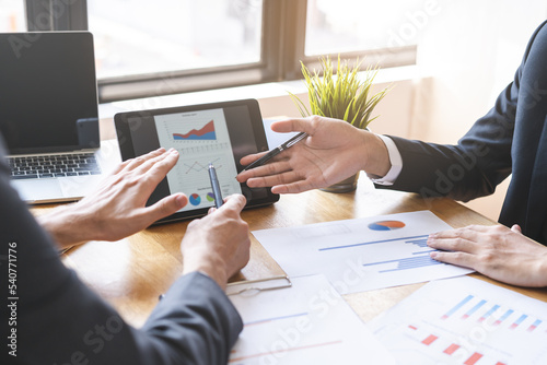Business meeting, two caucasian, asian group man use tablet brainstorm analyzing on graph data of cost plan or document, paperwork and discussing in board room on table. People working conference room