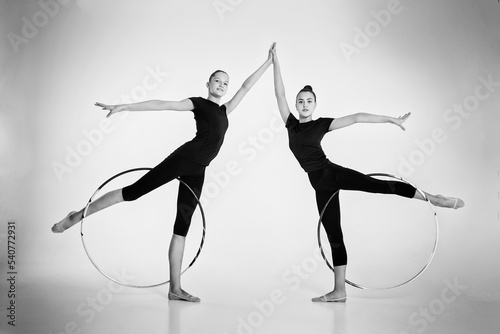Fotografie, Obraz a two girls from rhythmic gymnastics in a bodysuit show a deflection holding a h