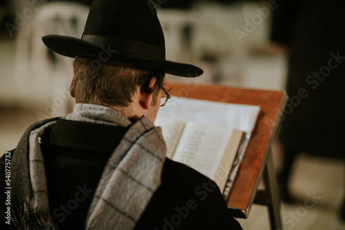 Orthodox Jewish man praying with torah at the western wall photo