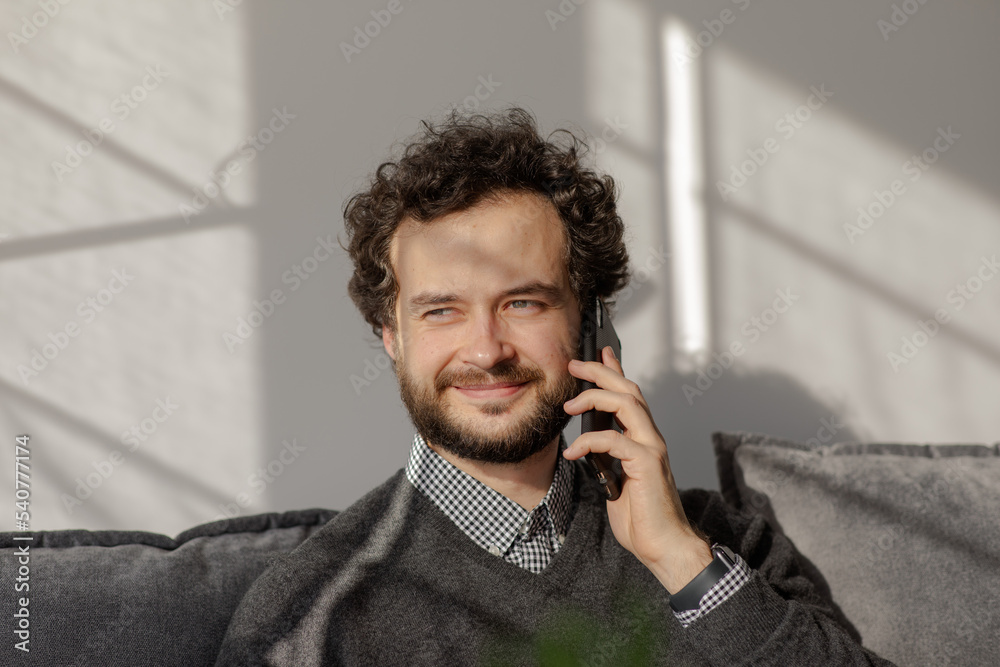 The man smiles on the phone..Portrait of a business man who speaks on the phone. Serious young man solves working questions.