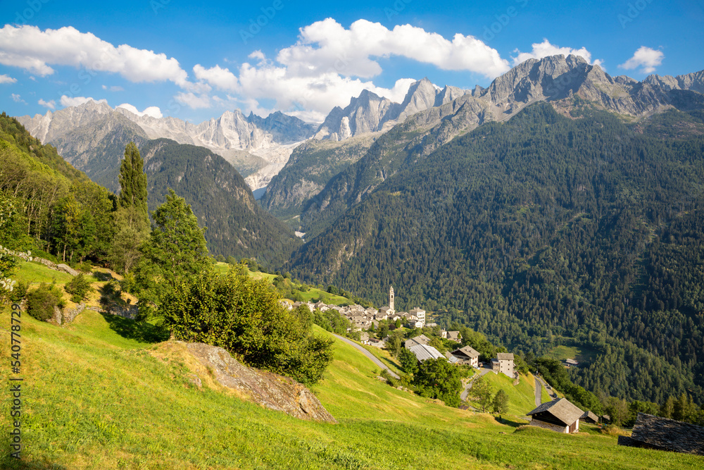 The Soglio village uder the alps meadows and Piz Badile, Pizzo Cengalo, and Sciora peaks in the Bregaglia range - Switzerland.