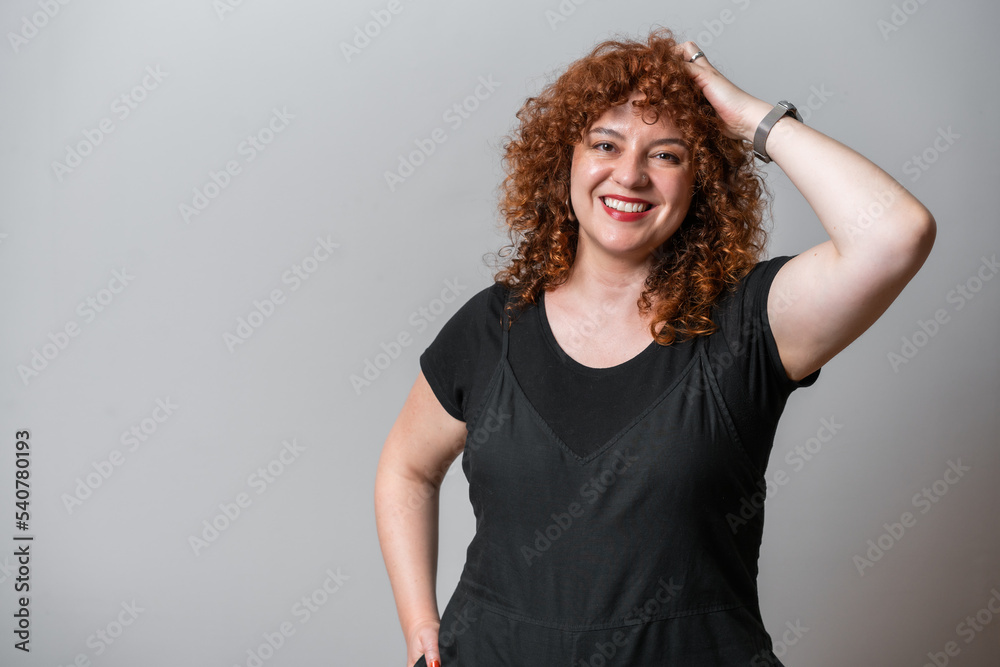 © Artframe  - Happy woman with red curly hair posing on grey background